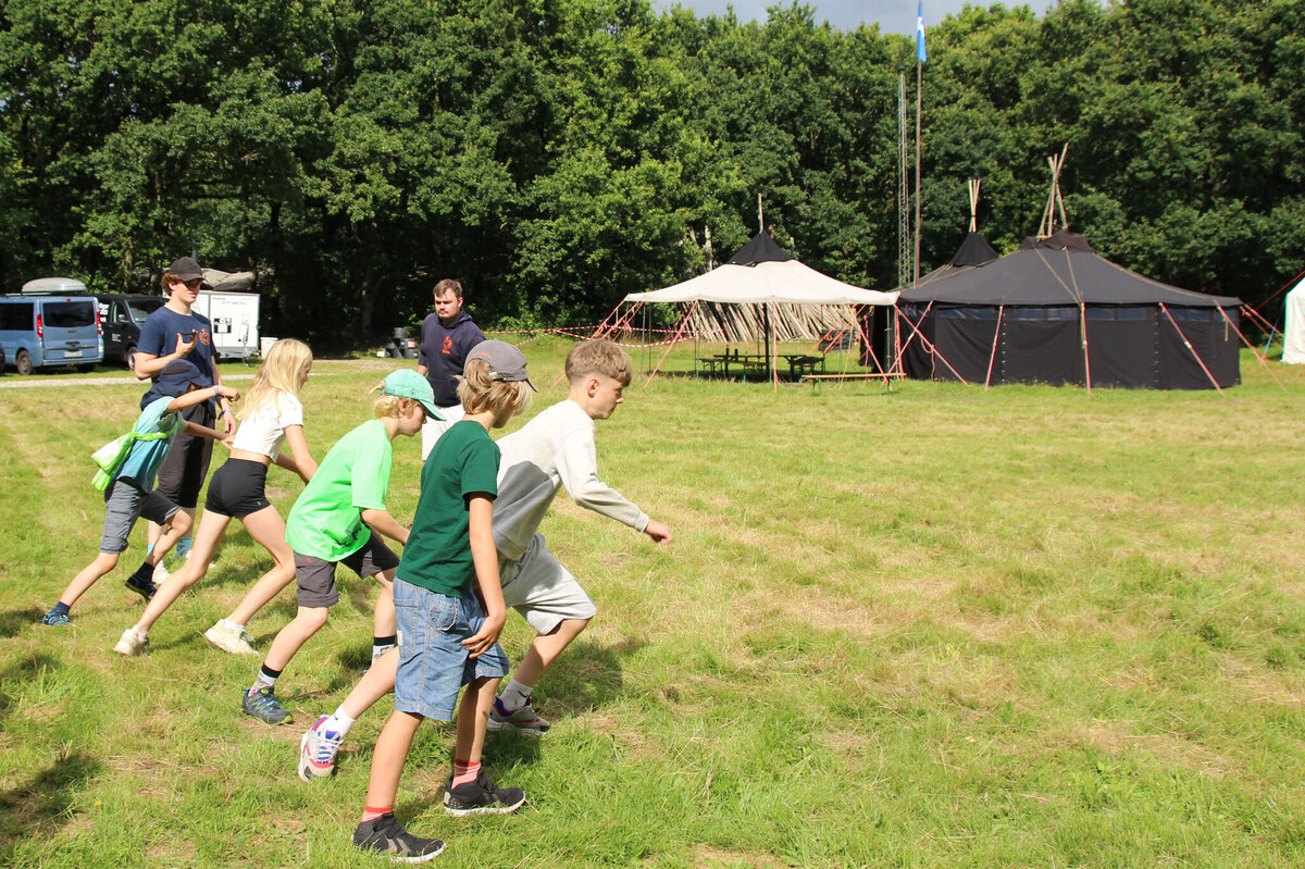 Kinder beim gemeinsamen Spielen und Rennen auf der Wiese
